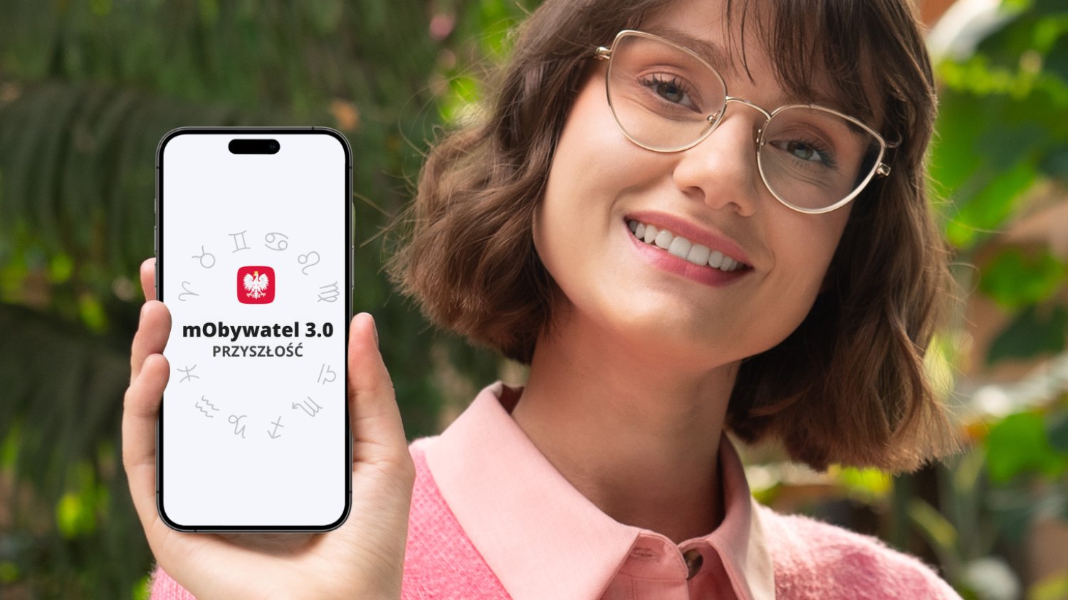 Na zdjęciu widzimy kobietę trzymającą telefon z otwartą aplikacją mObywatel.